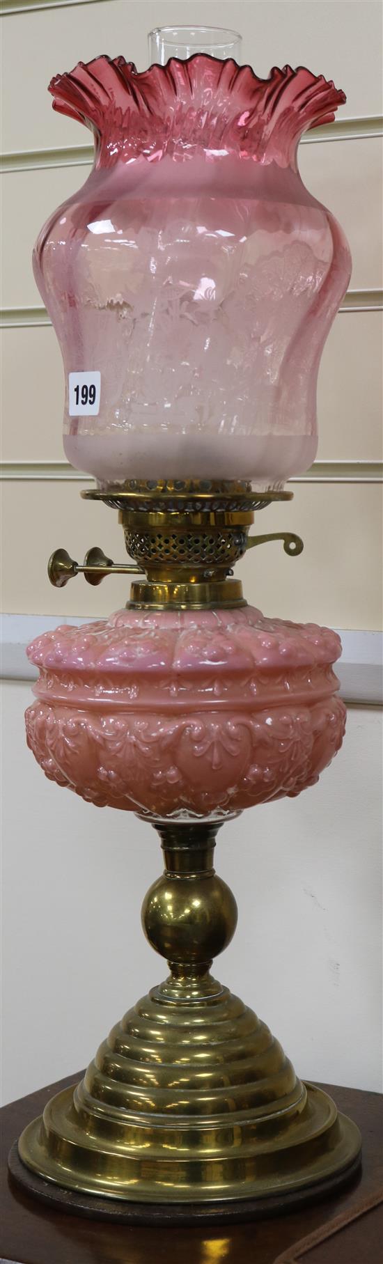 A cranberry and pink glass oil lamp and another similar
